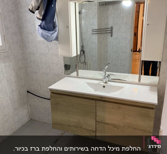כיור אמבטיה עם ברז ומראה גדולה